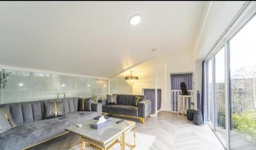 a living room with a couch and a table at New Modern Stylish Villa Near City Centre Birmingham, with outdoor Hot Tub in Birmingham