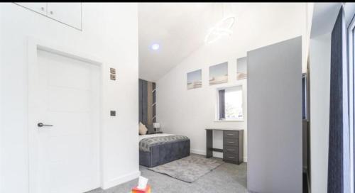a bedroom with white walls and a bed and a window at New Modern Stylish Villa Near City Centre Birmingham, with outdoor Hot Tub in Birmingham