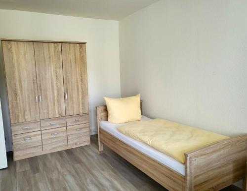 a small bedroom with a bed and a cabinet at Vario Gästehaus in Greifswald