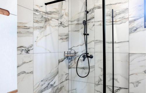 a shower in a bathroom with marble walls at Stunning Home In Jamno With Sauna in Jamno