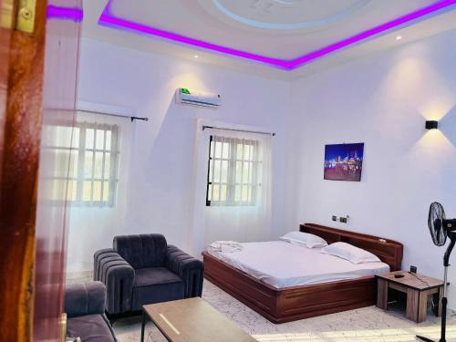 a bedroom with a bed and a couch and a chair at Les Résidences Terre Royale in Sokouhoué