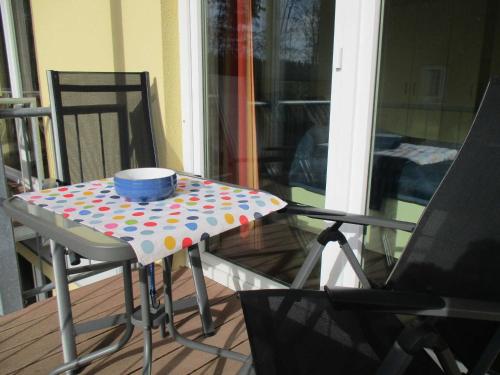 a table with a bowl on top of it on a porch at Apartment Fledermäuschen in Graal-Müritz