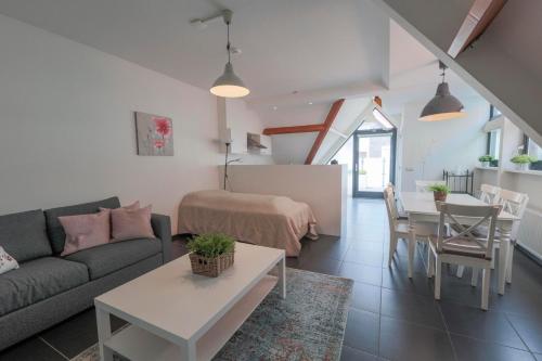 a living room with a couch and a table at Weststraat 22 - Ouddorp - Appartement Oost 3P in Ouddorp