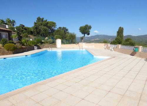 - une piscine avec de l'eau bleue et des chaises blanches dans l'établissement Ferienhaus mit Blick auf Grimaud, à Grimaud