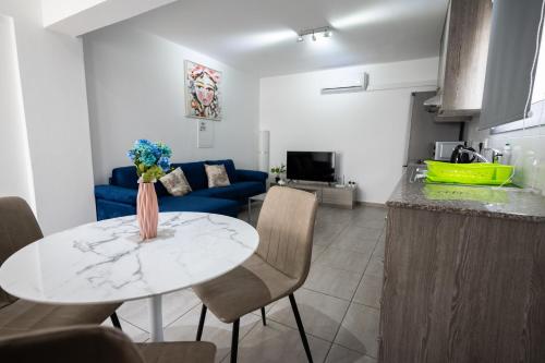 a living room with a table and a blue couch at Napa Centrale Suites in Ayia Napa