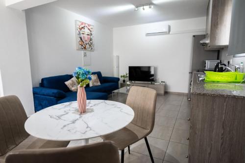 a living room with a table with a vase of flowers on it at Napa Centrale Suites in Ayia Napa