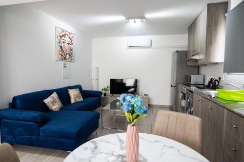 a living room with a blue couch and a table at Napa Centrale Suites in Ayia Napa