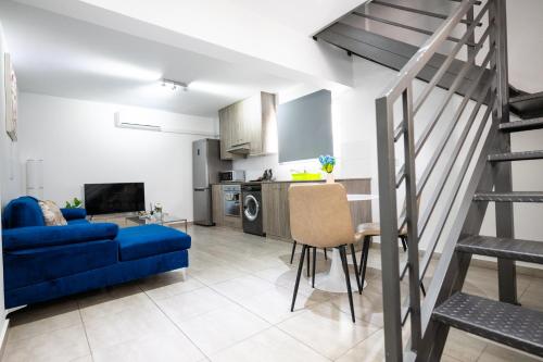 a living room with a blue couch and a kitchen at Napa Centrale Suites in Ayia Napa