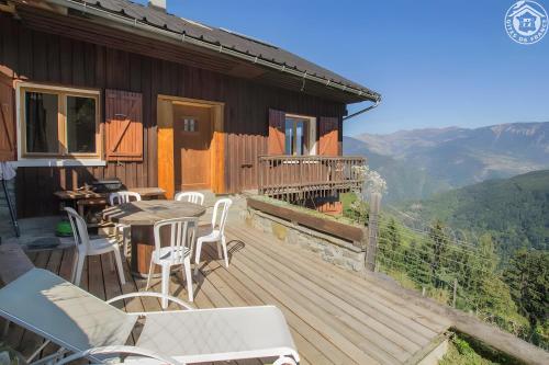 une terrasse en bois avec une table et des chaises sur une maison dans l'établissement Le Plan Du Fruit, à La Léchère