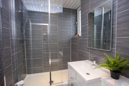 un bagno con doccia, lavandino e specchio di 3 Bed Cottage Flat with Parking a Glasgow