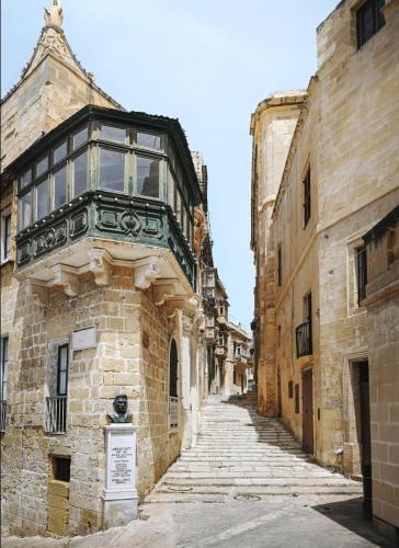 an alley with a balcony on the side of a building at Authentic studio with Maltese Balcony in Bormla by 360 Estates in Taʼ Penza