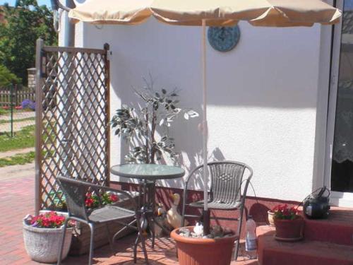 a patio with a table and chairs and an umbrella at Ferienwohnung Neuendorf in Neuendorf