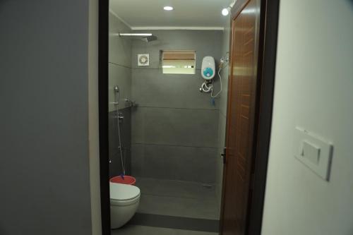 a small bathroom with a toilet and a shower at Poliyam Thuruth Eco Tourism Village in Kāsaragod