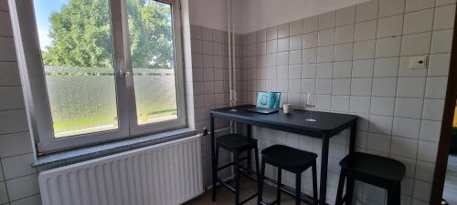 a bathroom with a table and two stools and a window at Southern Sun in Tilburg