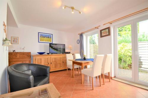 a living room with a table and chairs and a television at Apartment Strandstraße in Graal-Müritz