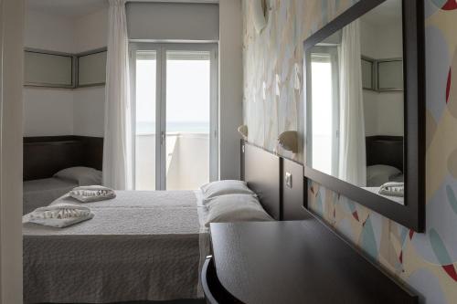 a bedroom with a large mirror and a bed at Hotel Croce di Malta e Mexico in Cesenatico