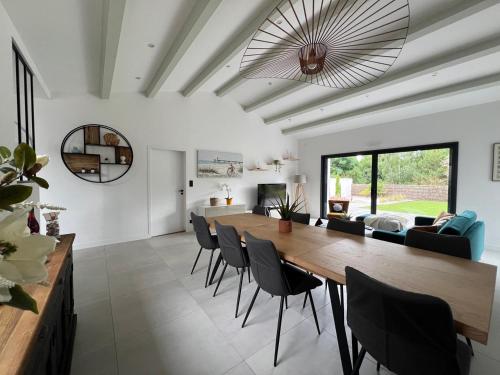 une salle à manger et un salon avec une table et des chaises dans l'établissement New Rethaise holiday home 8 people, au Bois-Plage-en-Ré