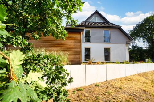 ヴィークにあるFerienwohnungen am Darßer Ort inkl Wäschepaketの白い柵の家