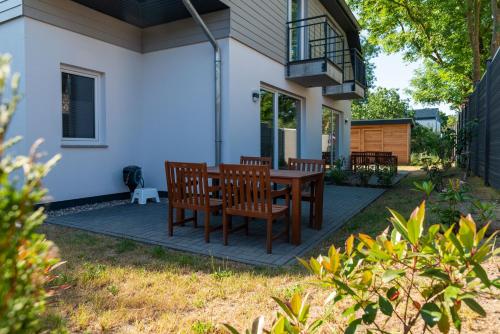 ヴィークにあるFerienwohnungen am Darßer Ort inkl Wäschepaketの木製テーブルと椅子付きのパティオ