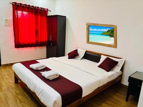 a bedroom with a large bed with red curtains at Samudrasneha Resort in Nagaon
