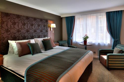a hotel room with a large bed and a window at The Collection Hotel Birmingham in Birmingham