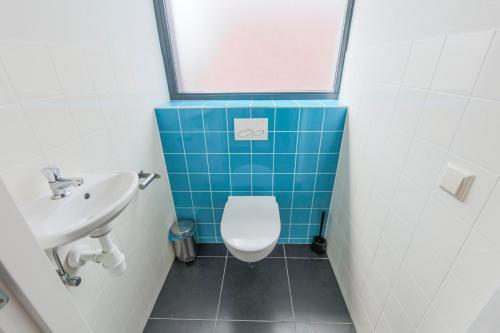 a small bathroom with a toilet and a sink at Weststraat 22 - Ouddorp - Appartement Oost 3P in Ouddorp