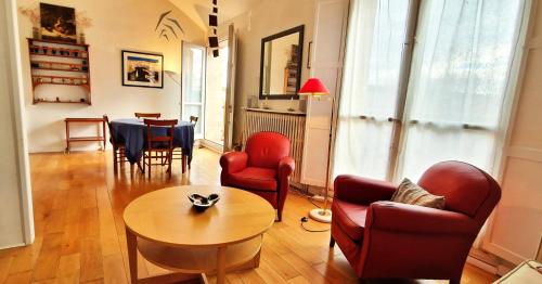 un salon avec des chaises rouges et une table dans l'établissement Spacious apartment 4 people parking, bright, à Aix-en-Provence