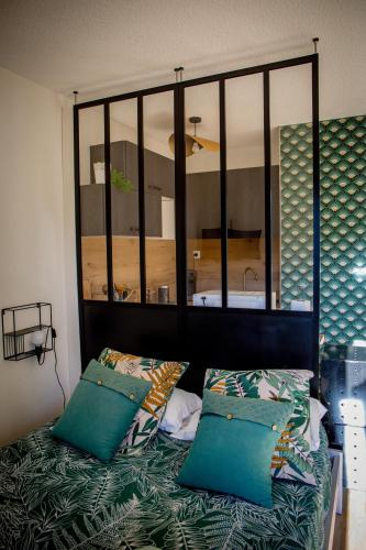 une chambre avec un lit avec des oreillers bleus dans l'établissement STUDIO ÉLÉGANT & MODERNE - ENTRE LAVANDE ET GORGES DU VERDON, à Gréoux-les-Bains