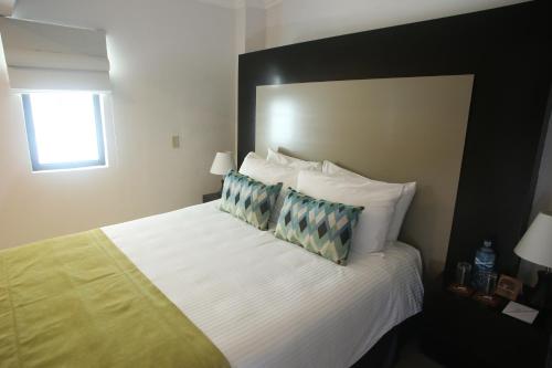 a hotel room with a large bed with two pillows at Aranjuez Hotel & Suites in David