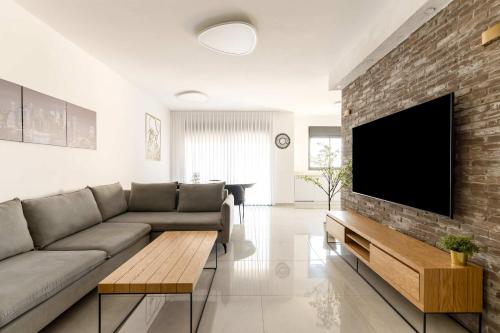 a living room with a couch and a flat screen tv at פנינת הקריות in Qiryat Ata