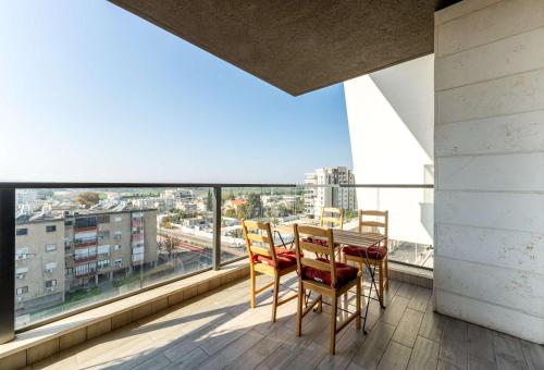 a balcony with a table and chairs and a large window at פנינת הקריות in Qiryat Ata