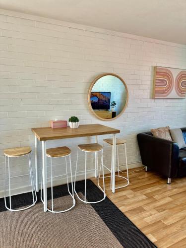 a table and stools in a room with a mirror at CENTRE FREMANTLE 2 queen bedroom APARTMENT in Fremantle