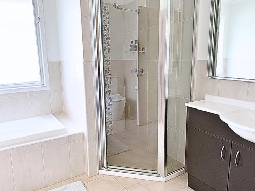 a bathroom with a shower and a toilet and a sink at 7kW EV Point,King Bed,1 Story Spacious All Ages Entertainer in Dunmore