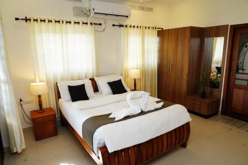 a bedroom with a large bed with white sheets at Wanderville in Vagamon