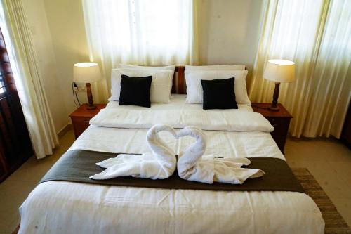 two swans towels on a bed in a hotel room at Wanderville in Vagamon