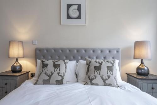 a bedroom with a white bed with two lamps at Riverside Apartment in London