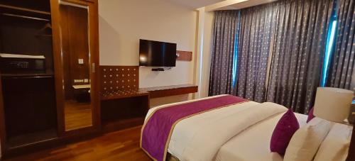Una televisión o centro de entretenimiento en Hotel Ger manus Madurai