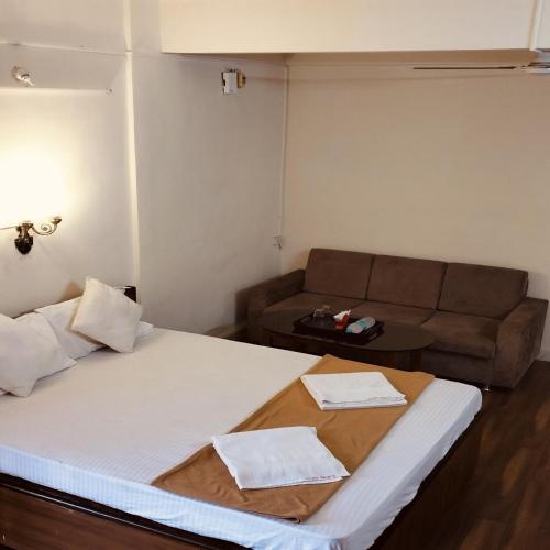 a living room with a bed and a couch at Hotel Vijay Palace Lodging Boarding in Bhiwandi