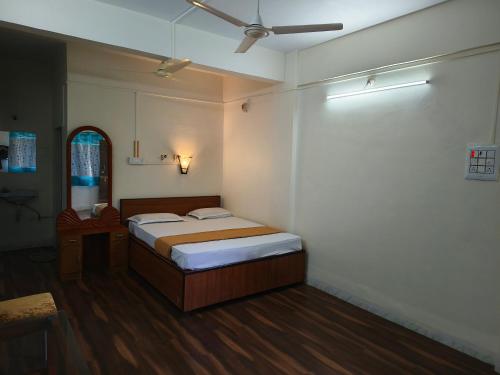 a bedroom with a bed and a ceiling fan at Hotel Vijay Palace Lodging Boarding in Bhiwandi