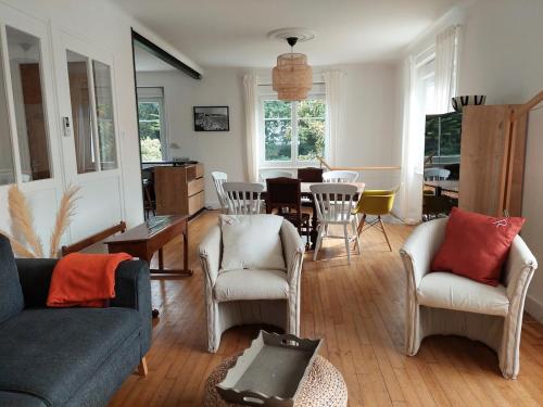 un salon avec un canapé, des chaises et une table dans l'établissement Ty Marion, plage et commerces à pied, à Fouesnant