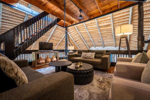 a living room with couches chairs and a table at Sunbirds Oasis Lodge in Hoedspruit