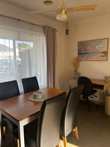 a dining room with a wooden table and chairs at Boho Beach Haven in Port Adelaide