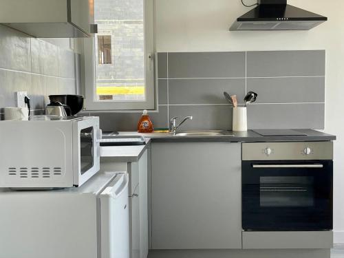 La cuisine est équipée d'un four micro-ondes et d'une cuisinière. dans l'établissement Bellavista #3 by Melrose, à Arromanches-les-Bains