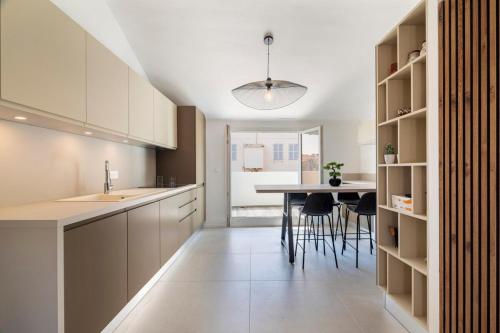 une cuisine avec des armoires blanches et une table et des chaises dans l'établissement 3 bedrooms 2 terraces in Cannes, à Cannes