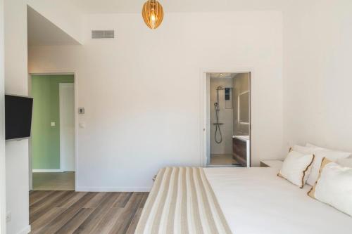 une chambre blanche avec un lit et une télévision dans l'établissement 3 bedrooms 2 terraces in Cannes, à Cannes