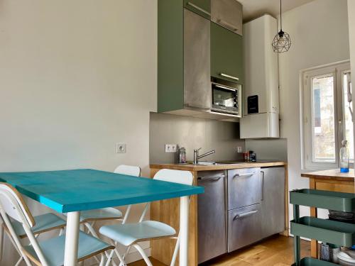 une cuisine avec une table bleue et des chaises dans l'établissement Deux pièces avec balcon, calme et ensoleillé, à Bordeaux