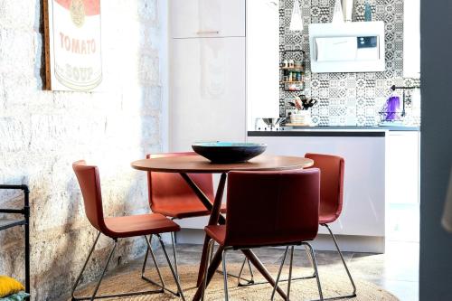 une cuisine avec une table en bois et quatre chaises dans l'établissement Aigues-Mortes remparts, renovated old apartment, à Aigues-Mortes