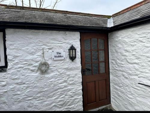 a white building with a door and a sign on it at The Stable -Plymouth in Plymouth