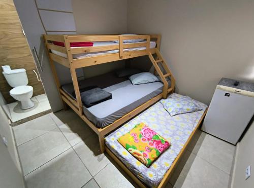 a small room with a bunk bed and a toilet at Pousada chc in Praia Grande