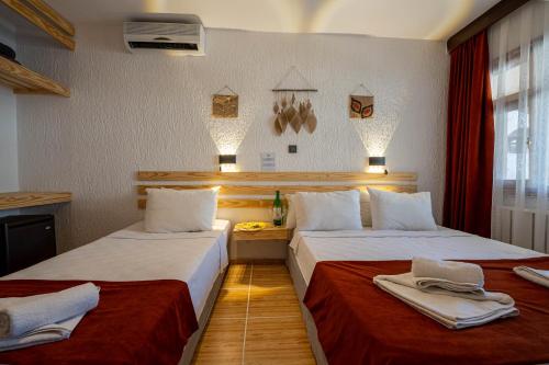 a hotel room with two beds with towels on them at Club Aquarium Hotel & Spa in Guvercinlik